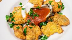 a white plate topped with fried food and sauce