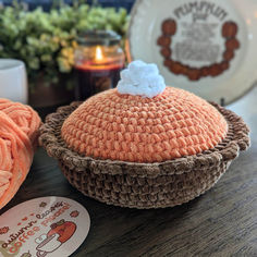 there is a crocheted basket with a white cloud on it and some other items next to it