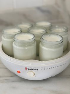 several jars filled with white liquid sitting on top of a counter