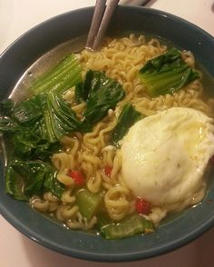 a bowl filled with noodles and vegetables on top of a table