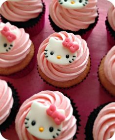 hello kitty cupcakes with pink frosting and bows on them are ready to be eaten