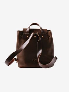 a brown leather handbag with straps on the front and side, sitting against a white background