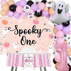 a pink and black birthday party with balloons, decorations and an animal themed banner that says spooky one