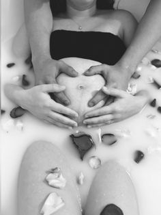 two women are sitting in a bathtub with their hands on top of each other