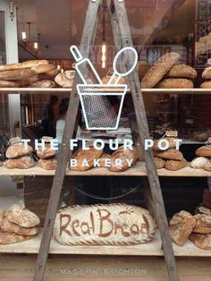 the flour pot bakery is selling fresh bread and loaves for sale in its window