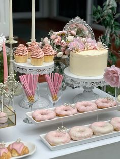 a table topped with lots of cakes and cupcakes