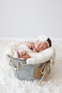 a newborn baby is sleeping in a bucket