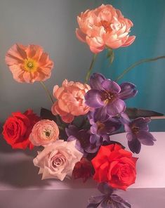 a vase filled with lots of different colored flowers