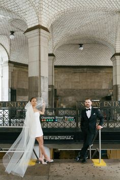 a bride and groom posing for a photo in the train station