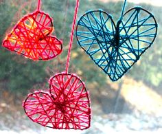 three hearts hanging from strings in front of a window