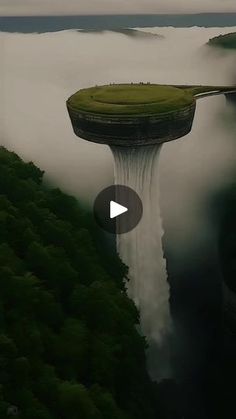 an island floating in the air surrounded by fog and mist, with a waterfall coming out of it