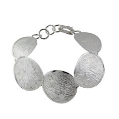 This sterling silver statement bracelet is an unparalleled conversation starter. The discreet way it captures the light and the large circles with cool textured finish can’t possibly go unnoticed. Wear it with a matching ring and earrings. 925 Sterling silver Reticulated/Textured finish Hook closure Approx. 8" L x 1.3" W Signed by the artist Handcrafted in Taxco, Mexico Elegant Sterling Silver Circle Bracelets, Modern Round Sterling Silver Bracelets, Modern Round Sterling Silver Bracelet, Disc Bracelet, Matching Rings, Statement Bracelet, Hammered Silver, Conversation Starters, Silver Bracelets