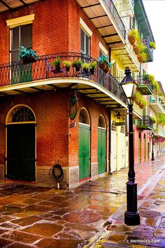 a street light sitting on the side of a road next to a tall red brick building