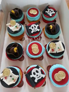 a box filled with cupcakes covered in pirate themed frosting