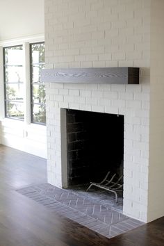 a white brick fireplace in an empty living room