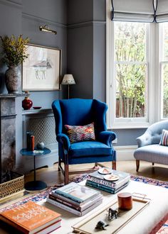 a living room filled with furniture and a fire place in front of a large window