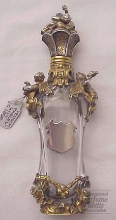 an ornate glass bottle with gold trimming