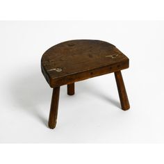 an old wooden stool with no legs on a white background or surface, it appears to have been used as a footstool