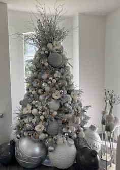 a white christmas tree with silver ornaments