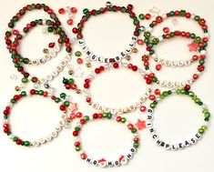 several bracelets with words and beads are arranged on a white surface, including the word holiday spelled in small letters