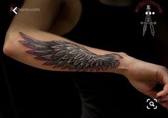 a person with a tattoo on their arm holding a knife and an angel's wing