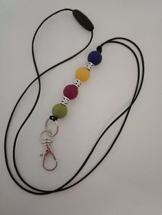 a long cord with different colored beads on it and a metal hook hanging from the end