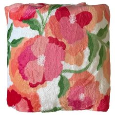 an orange and pink pillow with flowers on it