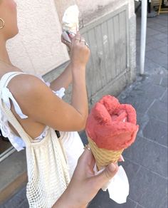 a woman is holding an ice cream cone in her hand