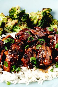 a plate with rice, broccoli and chicken on it next to green onions