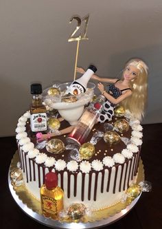 a birthday cake with a doll laying on top of it and some confection