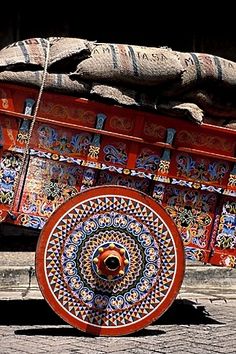 a colorfully painted wagon with wheels on the street