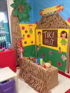 a tiki hut decorated with grass and hula skirt for the children's birthday party