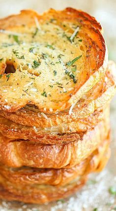 a stack of bread with cheese and herbs on top