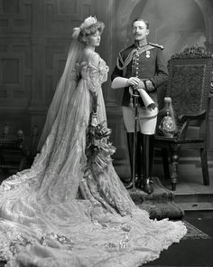 a man in uniform standing next to a woman wearing a wedding dress