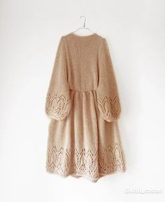 a sweater dress hanging on a white wall