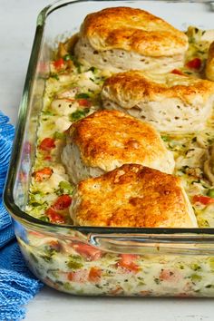 a casserole dish with chicken and vegetables in it next to a blue towel