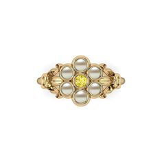 a gold ring with pearls and a yellow diamond in the center on a white background