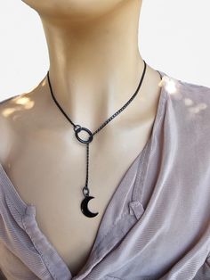 This is a bold and edgy blackened steel Gothic moon Lariat Necklace choker with a great Pagan witch aesthetic. This is a minimalistic, small curb chain with crescent moon charm.  The minimalist design gives it a trendy and stylish feel, while the black steel gives it a touch of gothic Punk edge. Please understand that this necklace is not designed for play, it is ornamental. This necklace is versatile and can be worn long or doubled up for a layered look, depending on what size you choose. Wrap it twice through the O ring to secure it in place.. PLEASE NOTE FOR RETURNS! If I accept returns on your purchase (check when ordering, some items are "no returns") your will receive a refund once I receive the item back, and your refund is MINUS  the original shipping fees, as I have already paid t Black Metal Jewelry With Moon Charm, Black Metal Moon Shaped Jewelry, Black Metal Moon-shaped Jewelry, Black Lariat Necklace As Gift, Gunmetal Adjustable Minimalist Jewelry, Gunmetal Minimalist Adjustable Jewelry, Black Lariat Necklace For Gift, Black Lariat Necklace With Adjustable Chain As Gift, Minimalist Adjustable Black Lariat Necklace