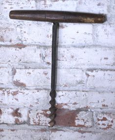 an old rusty wrench hanging on a brick wall