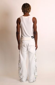 STERRE PEYTON CYBERIA CONTRA FLARED SWEAT PART OF THE NU SZN COLLECTION. THIS PANT INCLUDES A DRAWSTRING WAISTBAND AND A BUTTON FLY. THIS PANT INCLUDES FOUR POCKETS. THIS PANT FEATURES LONG ZIPPERS ON BOTH SIDES WHICH CAN BE OPENED AND ADJUSTED TO EXPOSE THE FLARED PANELS. EACH PANEL FEATURES THE SIGNATURE CONTRA DESIGN. THESE PANTS ARE MADE OUT OF A HEAVYWEIGHT COTTON JERSEY FOR WARMTH AND COMFORTABILITY. COLORS: White, Cream, Black This garment is a hand painted piece. Paint marks are to be ex White Hip Hop Pants With Cargo Pockets, White Parachute Pants With Hip Pockets For Streetwear, White Hip Hop Parachute Pants With Pockets, White Cargo Pants With Hip Pockets For Streetwear, White Wide Leg Hip Hop Pants, White Hip Hop Cargo Pants, White Hip Hop Wide Leg Cargo Pants, Hip Hop Style White Cotton Bottoms, White Wide Leg Cargo Pants Hip Hop Style