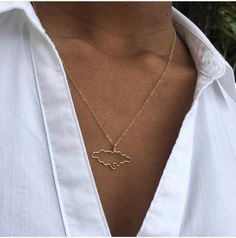 a woman wearing a gold necklace with the shape of a sheep on it's chest