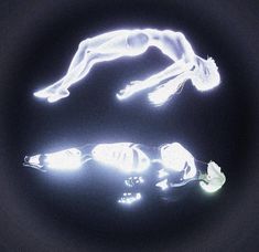 a person laying on their back in the dark with some light up objects around them