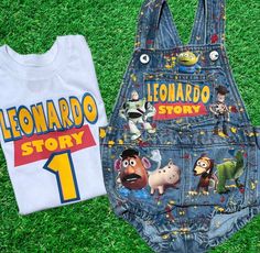 two children's clothing on the grass, one with an image of toy story characters