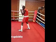 a man standing in a boxing ring wearing red shorts