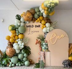 an animal themed birthday party with balloons, jungle animals, and giraffes