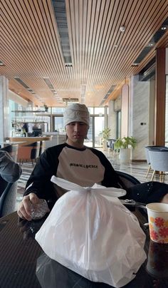 a man sitting at a table with a plastic bag in front of him