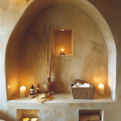 a spa room with candles, soaps and towels on the shelf next to it