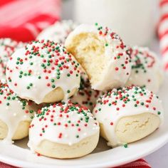 a white plate topped with cookies covered in frosting and sprinkles