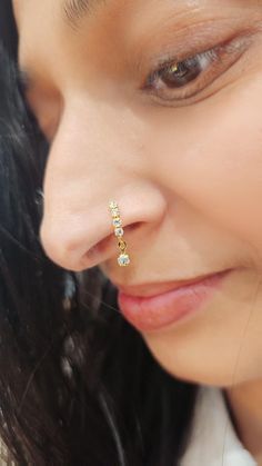 a close up of a person wearing a nose ring with small stones on the side