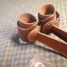 a pair of brown leather shoes sitting on top of a bed next to a bag